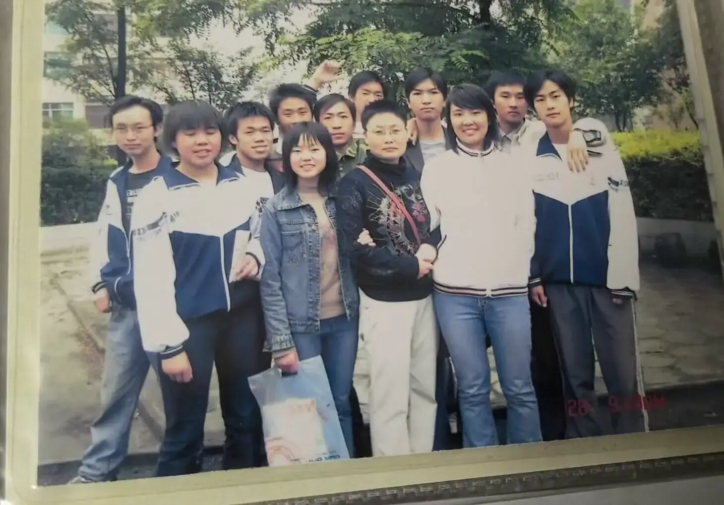 2006年语文课堂外的温馨瞬间,212班同学们围绕在语文老师身旁的合影。老师手中还拿着刚讲解完的《滕王阁序》课本,而我们青涩的笑容里满是对未来的憧憬,文学滋养的青春在快门声中永恒定格。