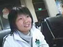 2006年网吧文化纪实，汪建美在泛着蓝光的电脑摄像头前自拍的青涩影像。背后隐约可见的QQ聊天界面和模糊的网吧环境，瞬间将我们拉回那个用'你是GG还是MM'开启社交的纯真年代。