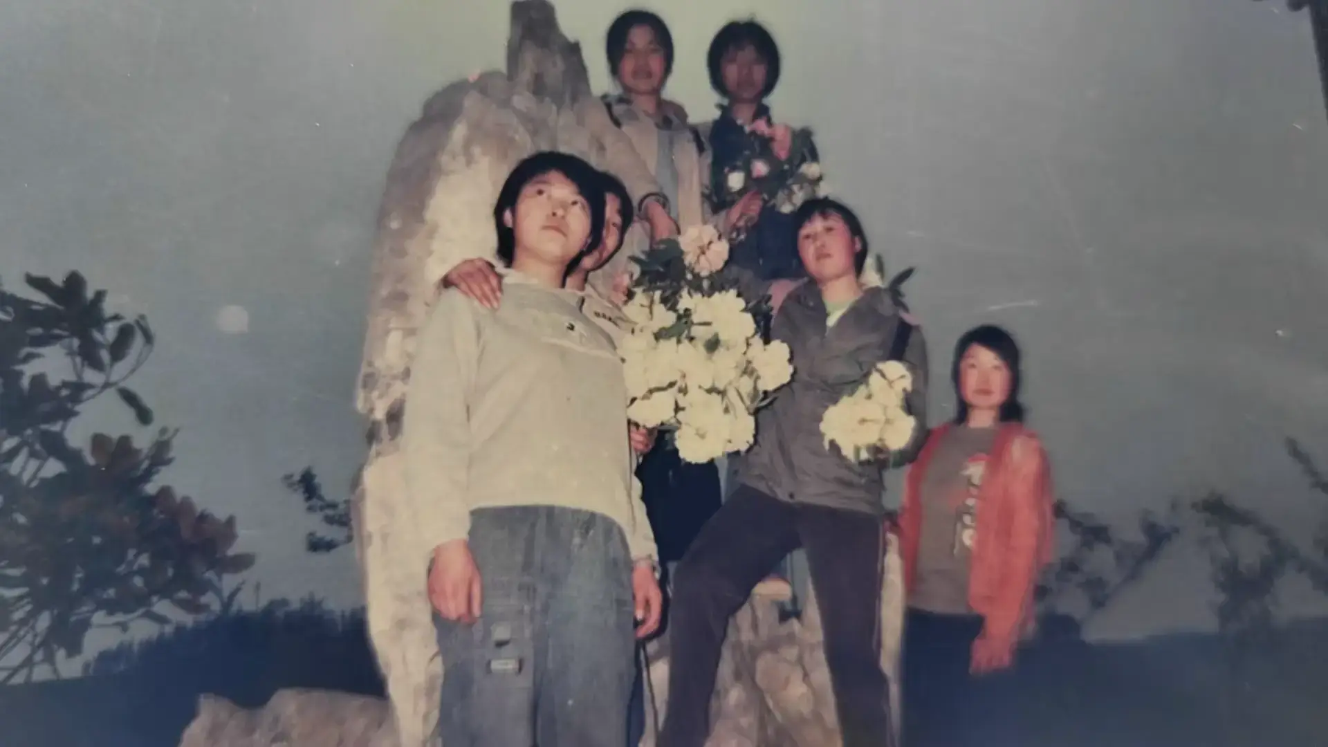 2006年校园姐妹淘珍贵合影，龙静、朱娇、王徐梅、廖芳、张涛五人在紫藤花架下的亲密留影。女生们或挽手或搭肩的姿势，定格了212班女生间最纯粹的友情瞬间，那些说不完的悄悄话和突然爆发的笑声，都藏在这张泛黄的照片里。