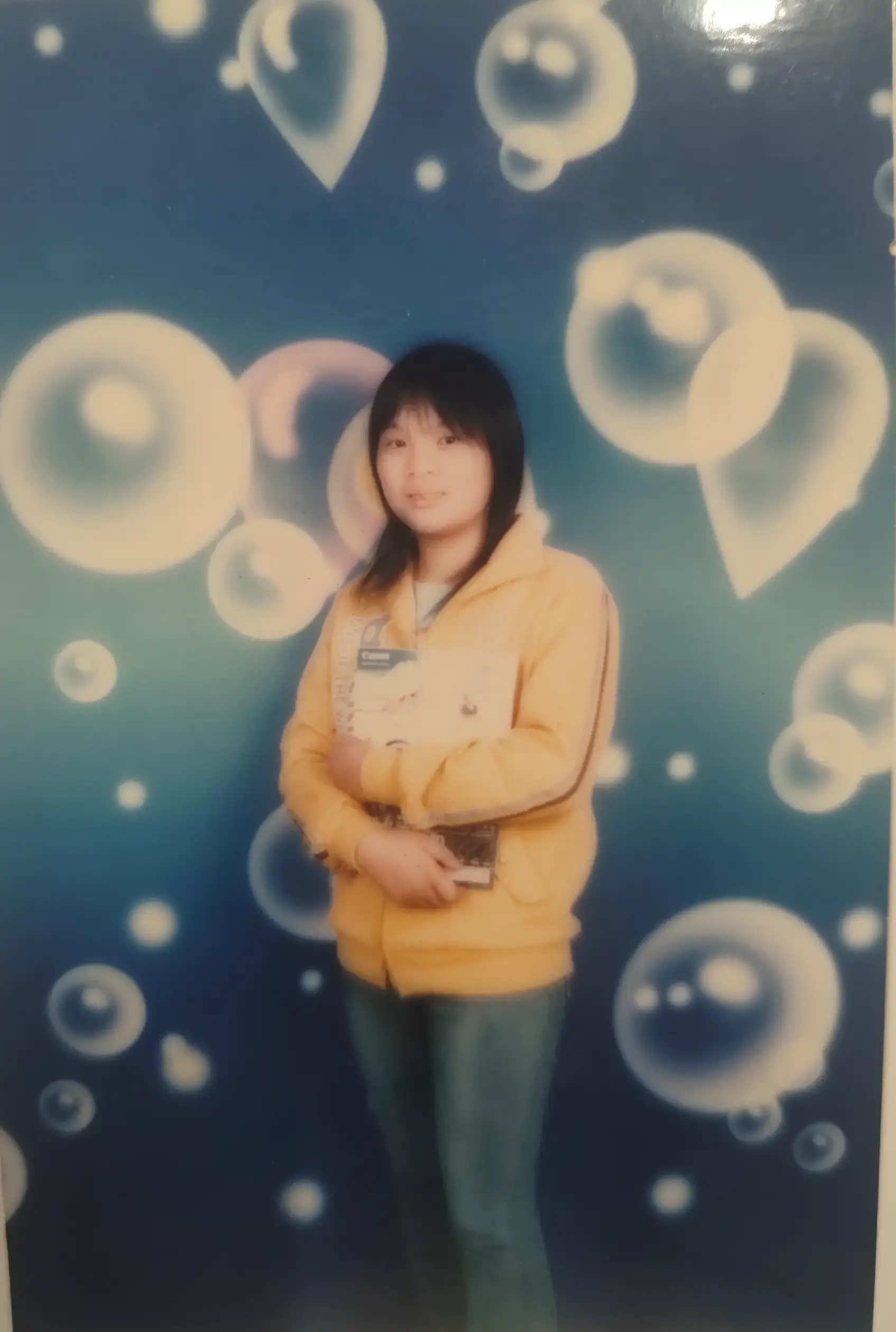 蓝色背景前，吴淑微微抿着嘴角，那时候女生们都喜欢把头发扎得整整齐齐再来拍照。